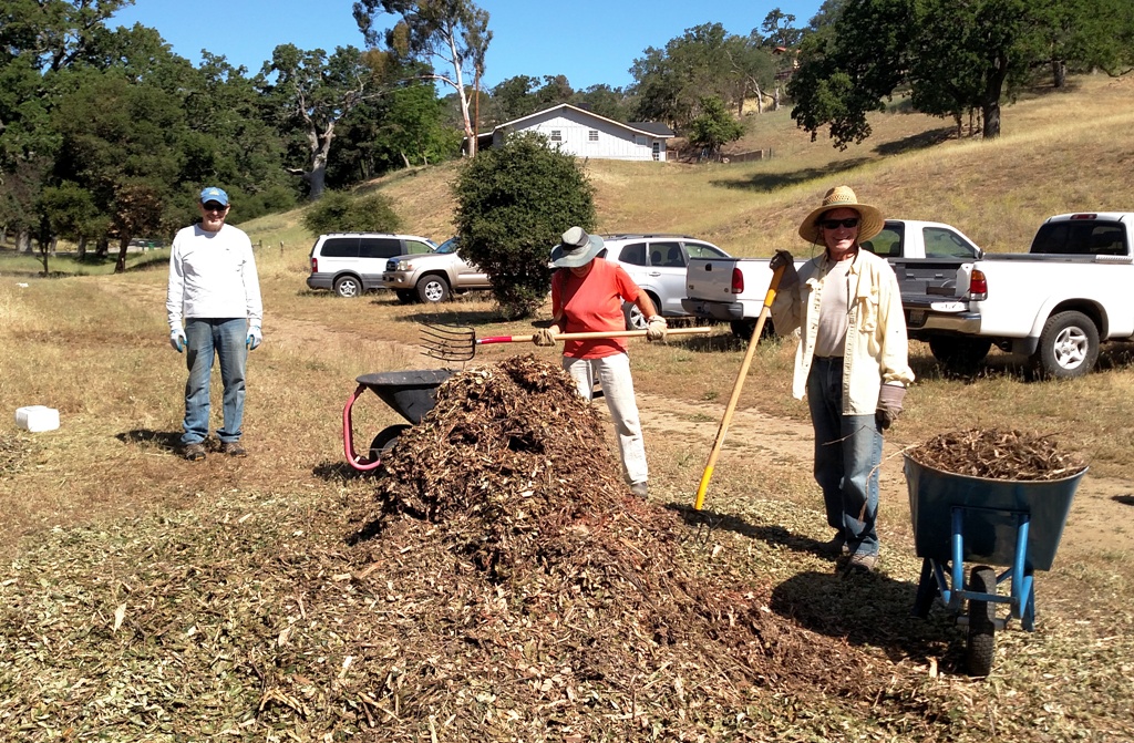 Clyde, Judy and Michael loading wheelbarrows with mulch!